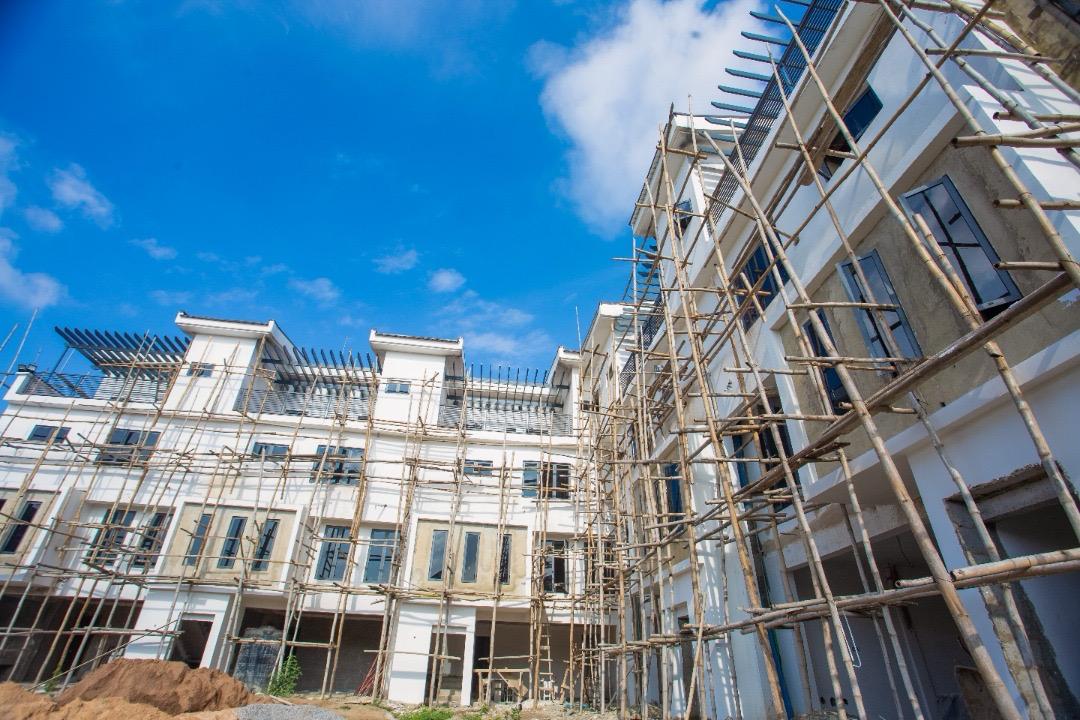 Angled view of The Ivory white rendered facade and window openings against a clear sky
